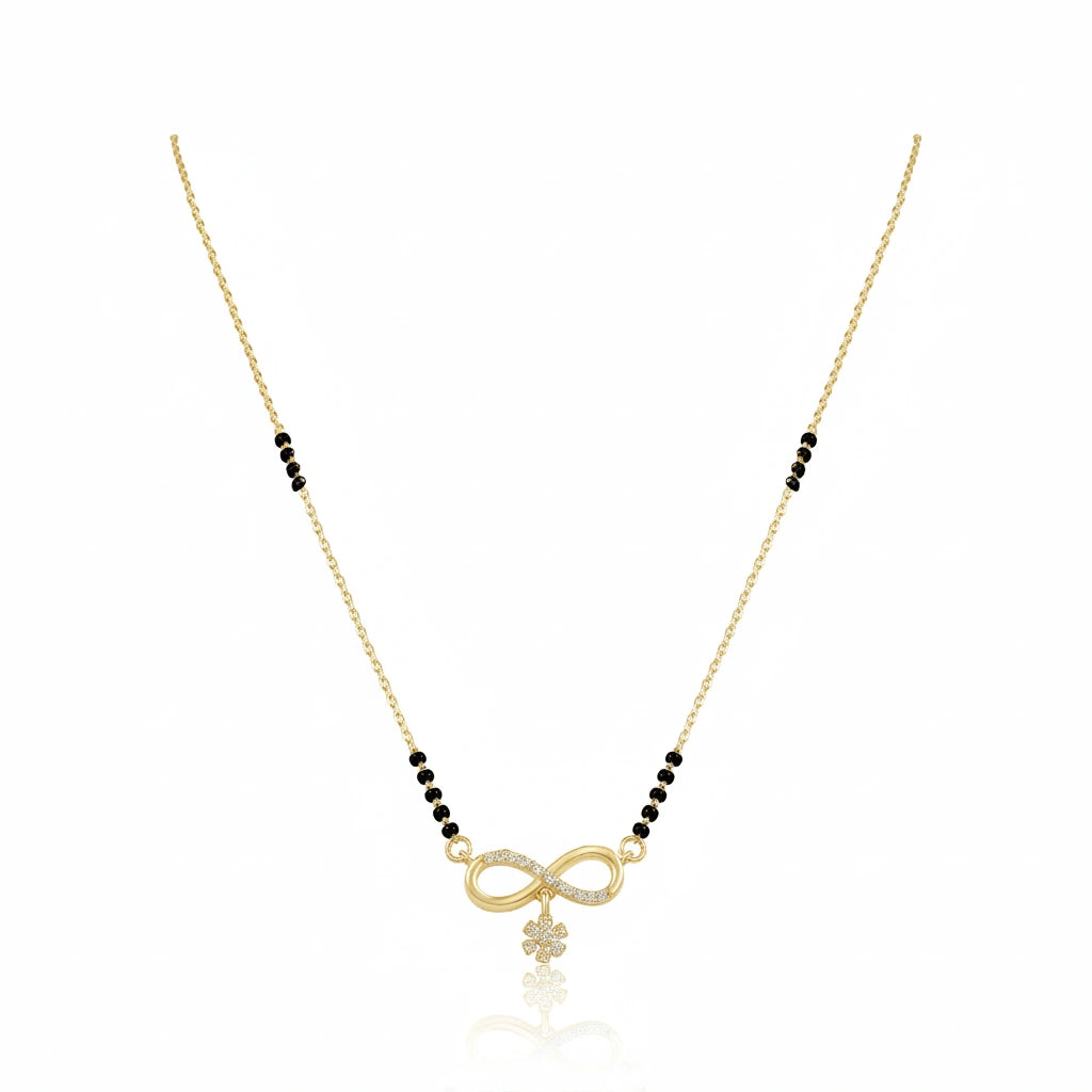 Gold infinity mangalsutra with black bead chain, diamond-studded infinity symbol and floral drop pendant on white background