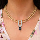 Woman wearing diamond silver U-shaped pendant with black Shri Radha charm on layered gold bead necklace